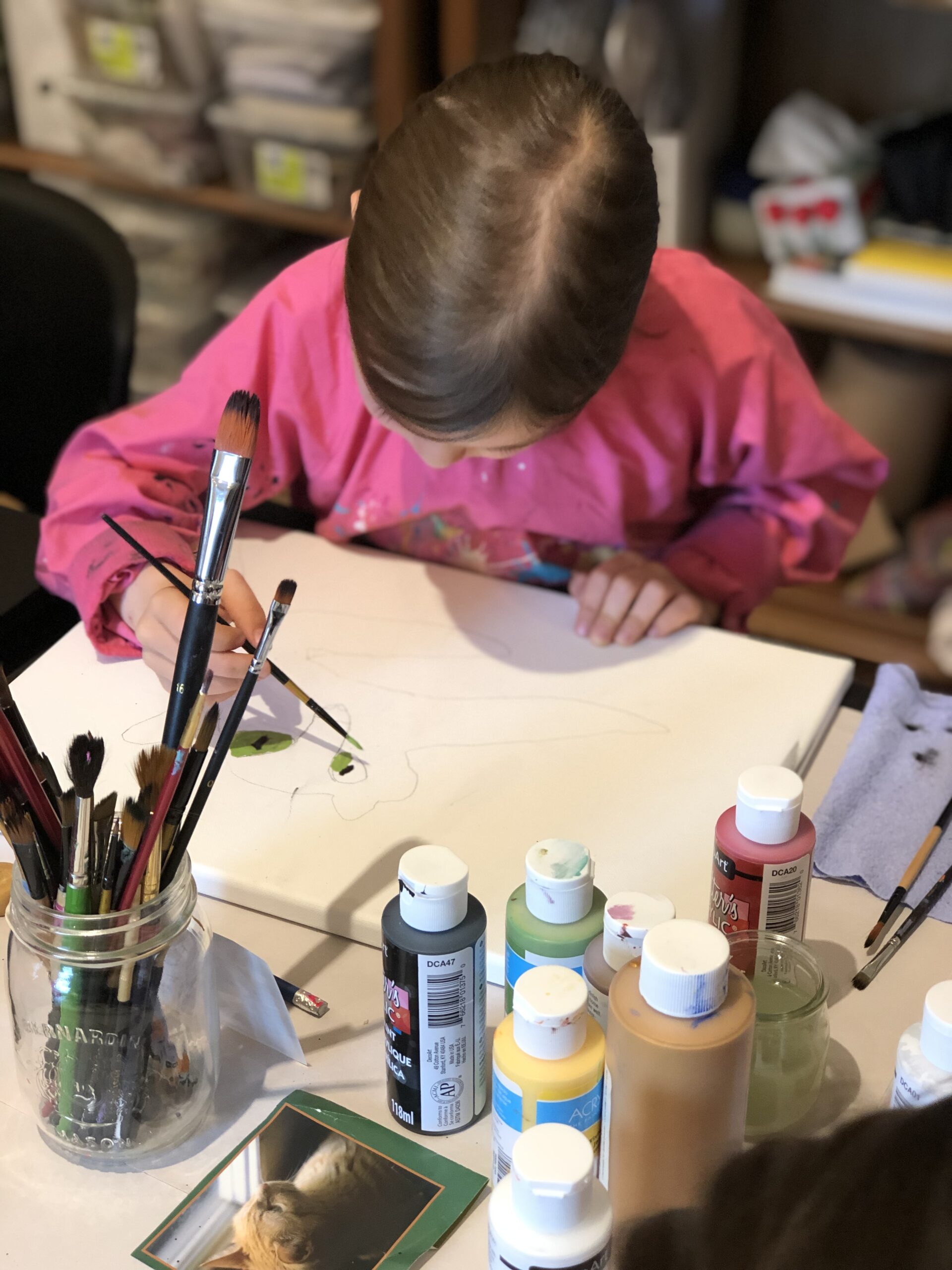 Atelier art intuitif jeune fille avec cheveux brun qui peinture une toile camp de jour